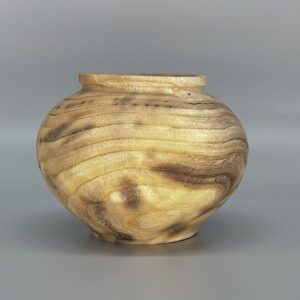 A wooden bowl sitting on top of a table.