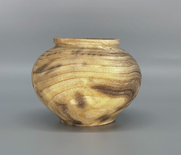 A wooden bowl sitting on top of a table.