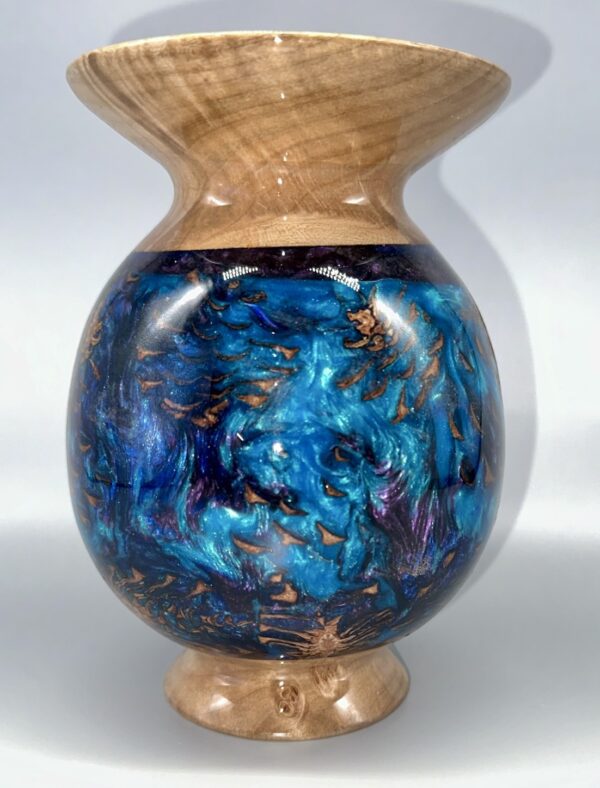 A blue vase with gold and black swirls