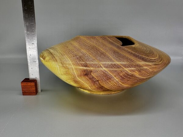 A wooden bowl with a leaf design on it.