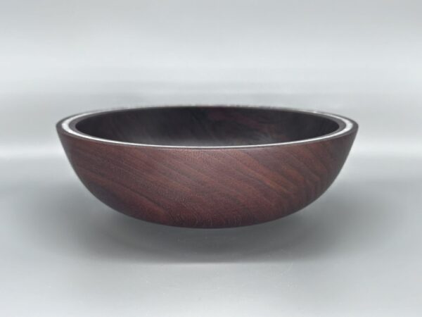 A bowl with a brown rim and black inside.